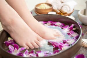 spa treatment product female feet hand spa orchid flowers ceramic bowl