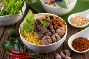 yellow noodles cup with crispy pork slices pork meatballs together with thai food style noodles