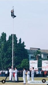 Seorang peserta upacara memanjat hingga ujung tiang bendera untuk mengambil tali bendera yang terlepas saat Upacara HUT Kemerdekaan RI ke-78 di Lapangan Rempoa Gintung, Ciputat Timur, Jakarta, Kamis (17/8/2023). Foto: Infojabodetabek